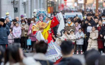 На фото: туристы смотрят представление на Золотой улице во время праздника Весны в Тяньцзине, Китай.