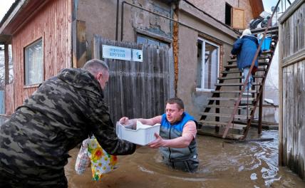 На фото: люди на подтопленной улице Красная. Свыше 300 домовладений подтоплено в Оренбурге за ночь, еще около 200 может быть подтоплено в ближайшее время.